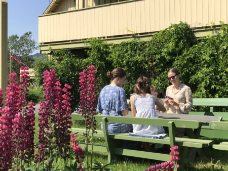 Gjester som koser seg med kortspill på et bord i hagen til Bjørnstjerne Bjørnson.